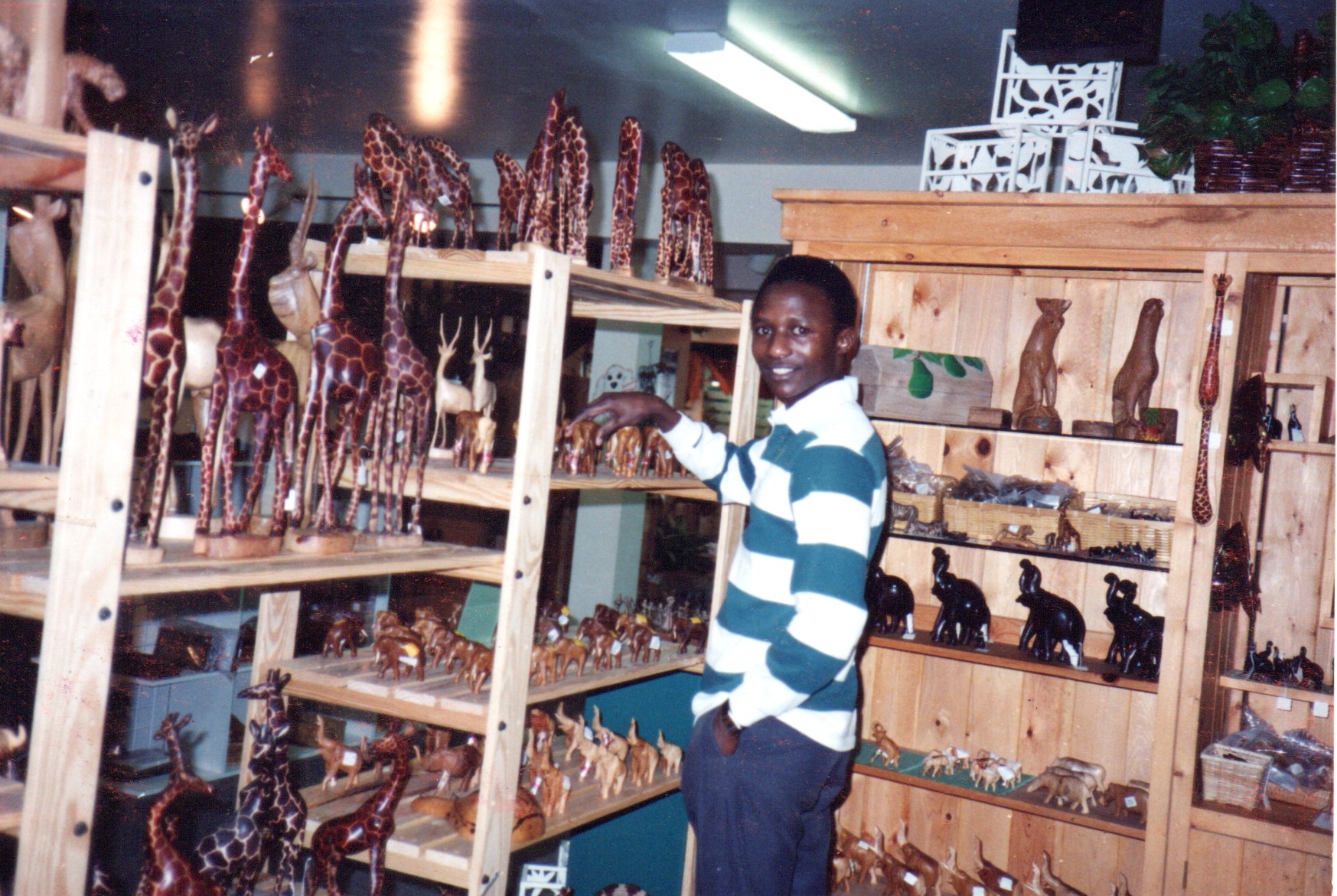 Man standing in front of shelves with animal figures.